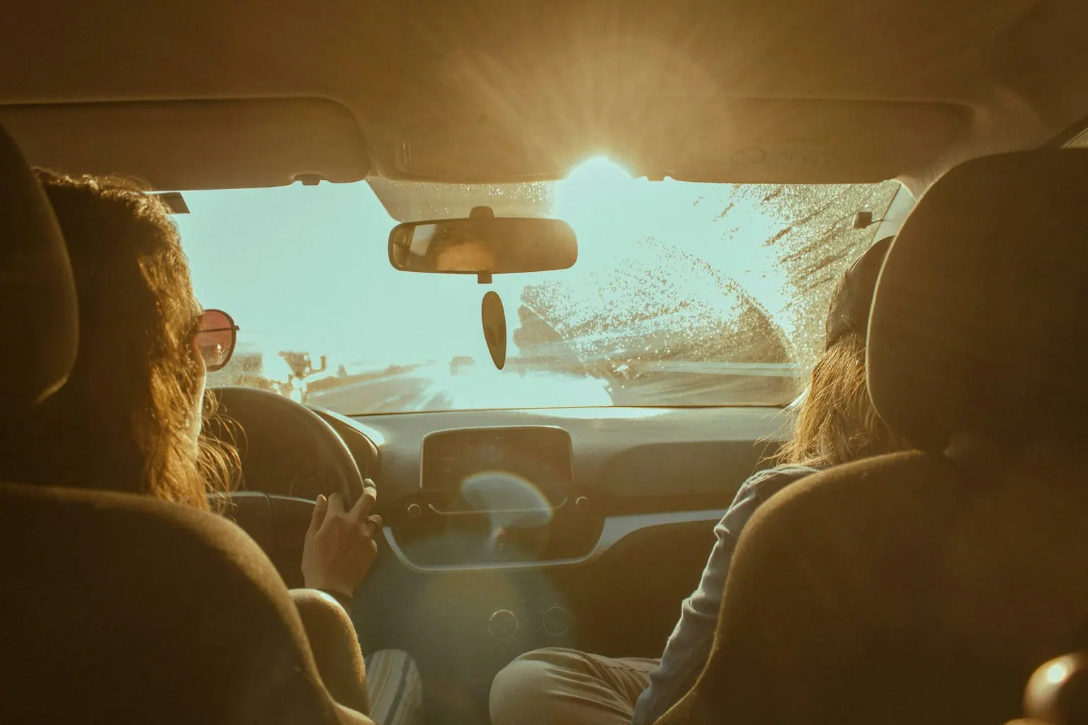 Jeunes passagers dans une voiture au soleil couchant